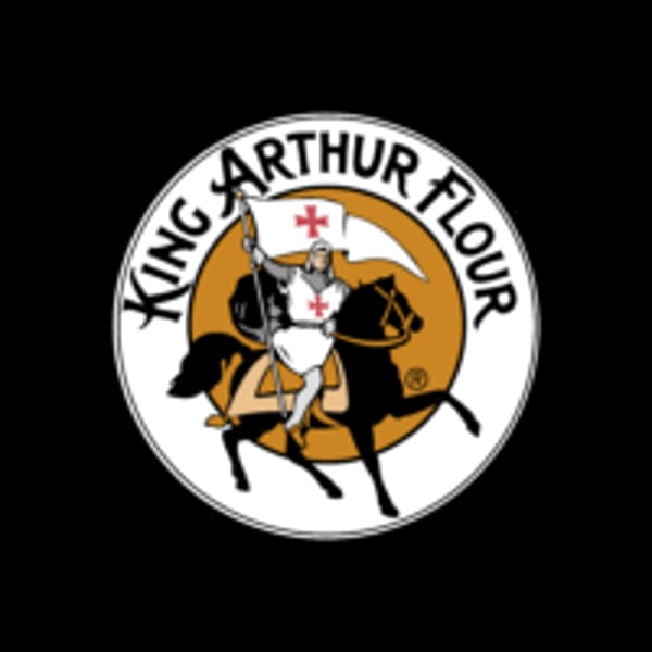 King Arthur Flour logo featuring a knight on horseback holding a flag with a red cross.