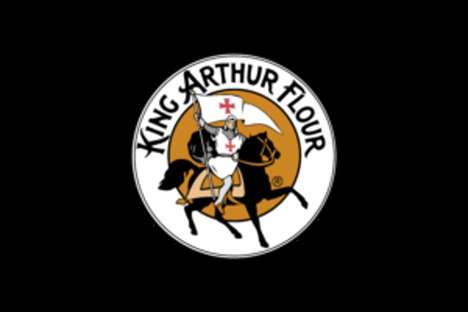 King Arthur Flour logo featuring a knight on horseback holding a flag with a red cross.